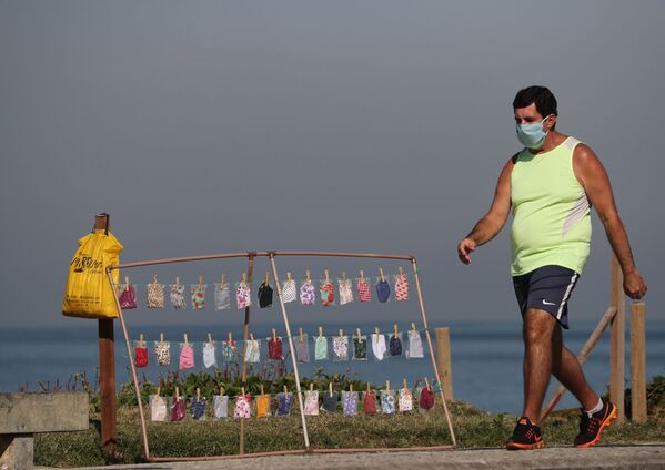 Мужчина в защитной маске на пляже в Рио-де-Жанейро, Бразилия - Sputnik Azərbaycan