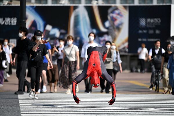 Человек в костюме Человека-паука прыгает на улице Токио - Sputnik Азербайджан