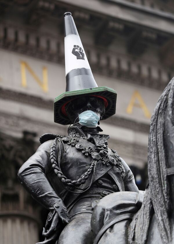 Конная статуя герцога Веллингтона с дорожным конусом на голове и с маске после акций протеста в Глазго, Великобритания - Sputnik Азербайджан