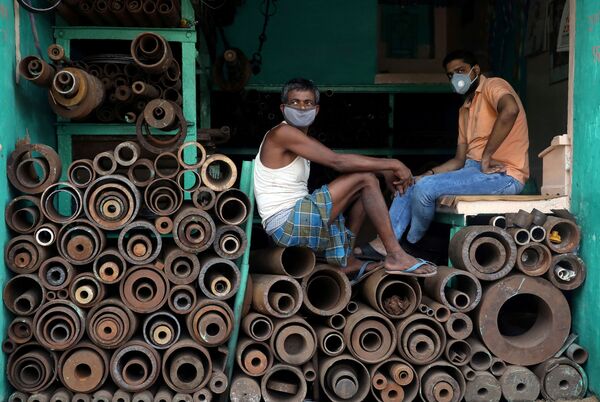 Рабочие в защитных масках в магазине, торгующем железными трубами на оптовом рынке в Калькутте, Индия - Sputnik Азербайджан