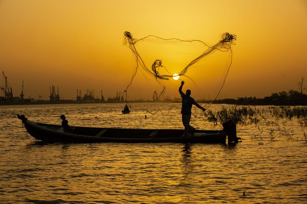  Рыбак закидывает сеть на закате на реке Шатт-эль-Араб в иракском городе Басра - Sputnik Azərbaycan