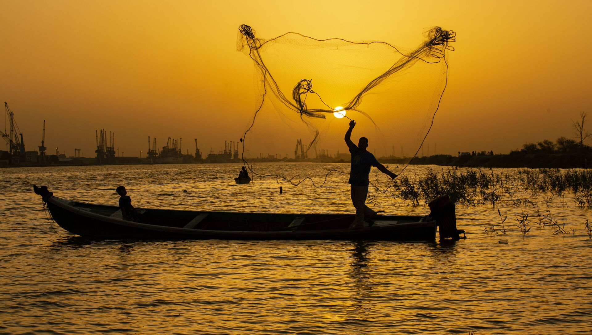  Рыбак закидывает сеть на закате на реке Шатт-эль-Араб в иракском городе Басра - Sputnik Азербайджан, 1920, 06.09.2021