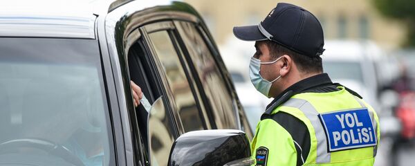 Сотрудник дорожной полиции проверяет разрешение водителя для выходы на улицу - Sputnik Азербайджан