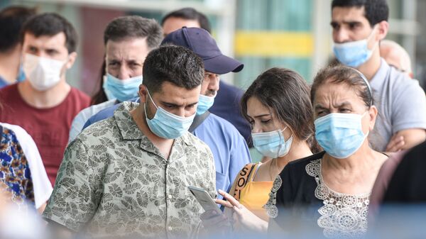 Люди в защитных масках на улице в Баку во время особого карантинного режима - Sputnik Азербайджан