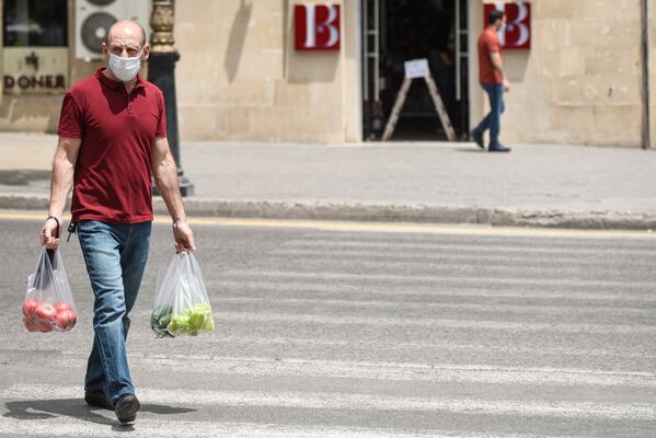 Мужчина в защитной маске на улице в Баку во время особого карантинного режима - Sputnik Azərbaycan