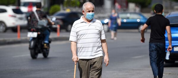 Мужчина в защитной маске на улице в Баку во время особого карантинного режима - Sputnik Азербайджан