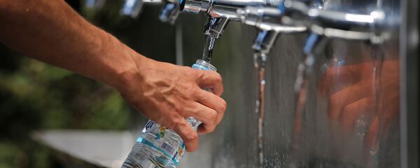 Мужчина наполняет бутылку водой, фото из архива - Sputnik Азербайджан