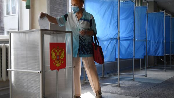 Женщина принимает участие в голосовании по внесению поправок в Конституцию РФ в Новосибирске - Sputnik Azərbaycan