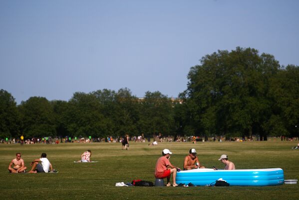 Люди отдыхают в надувном бассейне в Лондоне, Великобритания - Sputnik Азербайджан