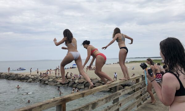 Девушки прыгают с моста в пруд в Эдгартауне, штат Массачусетс - Sputnik Азербайджан