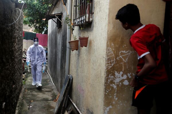 Медработник в защитном костюме делает обход в трущобах Мумбаи, Индия - Sputnik Азербайджан
