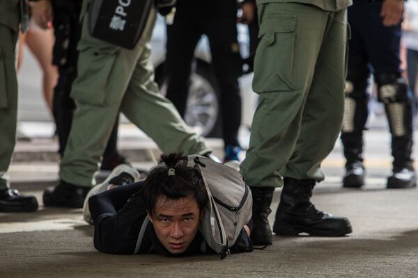 Задержанный участник акции протеста против нового закона о национальной безопасности в Гонконге - Sputnik Азербайджан